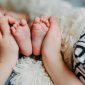 persona agarrando los pies de un bebe